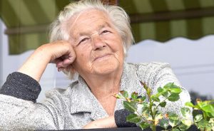 Senior woman leaning on hand and looking forward.